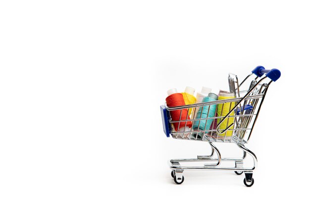 Trolley with thread on a white background . Thread selection. Shopping for needlework. White background. Copy space