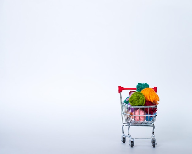 Trolley with yarn for knitting Needlework Hobbies and recreation Colored threads on a white backgrou