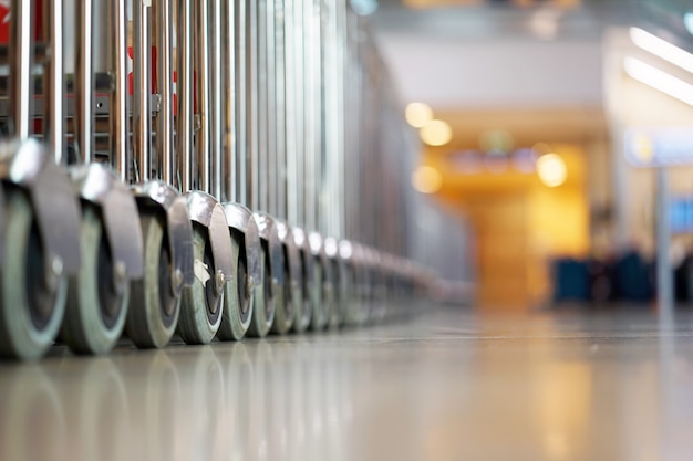 Trolleys luggage in a raw in airport. Close-up view trolleys luggage in airport. Luggage carts at modern airport. Selective focus.