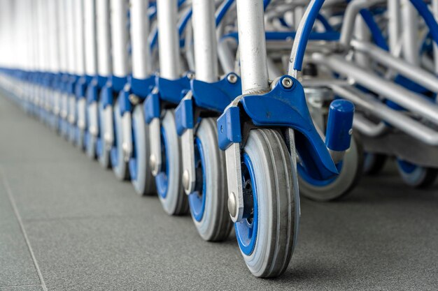 Trolleys luggage in a row in modern airport Close up of luggage carts