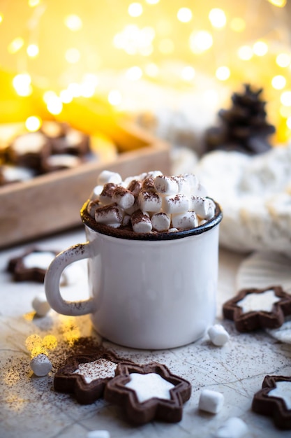 Troostende kerstmok warme chocolademelk met marshmallow en koekjes met gezellige lichtjes