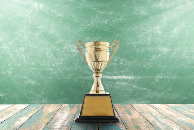 Trophies placed on a wooden table with blackboard background