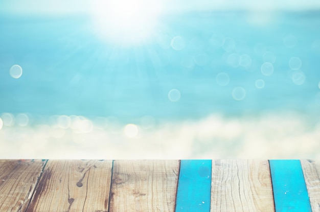 Foto spiaggia tropicale sfocata su uno sfondo di tavolo di legno bianco scenario naturale per la presentazione di un prodotto