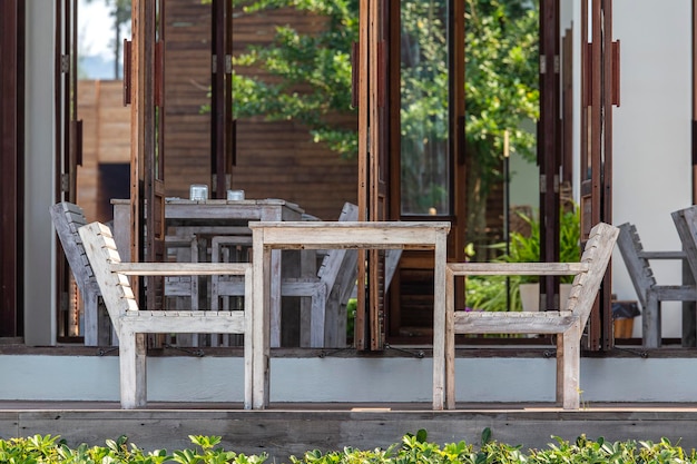 Bar sulla spiaggia tropicale con tavolo e sedie in legno thailandia mobili rustici in legno su un balcone vicino al mare