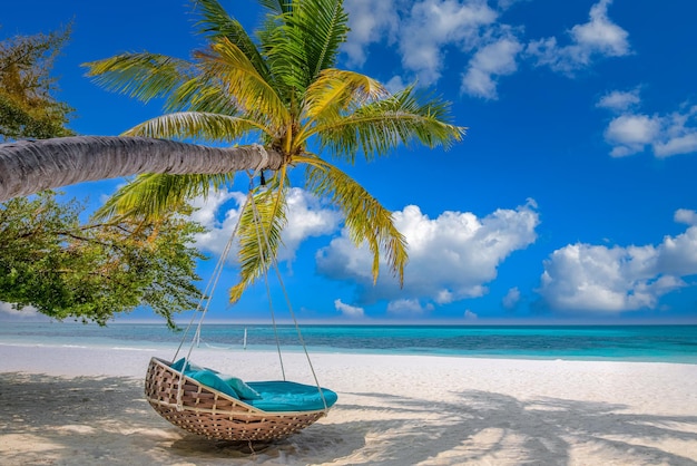 Tropical beach panorama as summer landscape with beach swing or hammock and white sand and calm sea