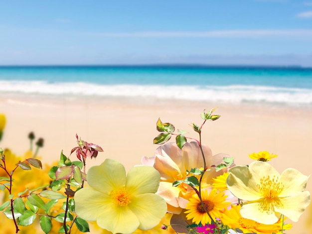 ピンクの白い花とヤシの植物の青い海と空の白い砂浜のある熱帯のビーチ