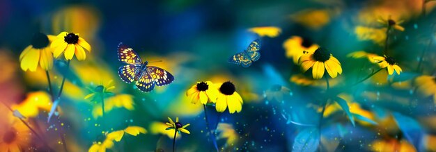Tropical butterflies and yellow bright summer flowers on a background of colorful foliage in a fairy garden Macro artistic image Banner format