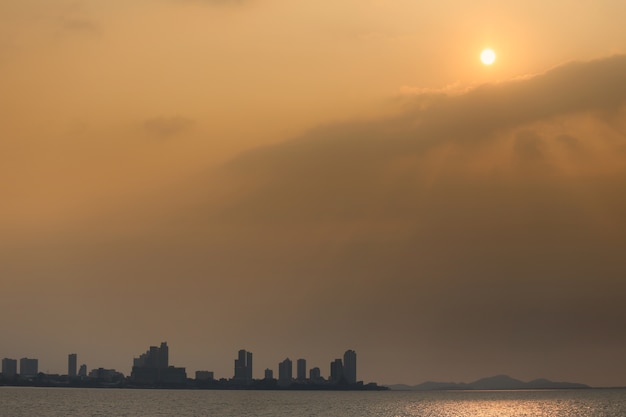 太陽からのオレンジ色の光で夕方の熱帯海岸の眺め。