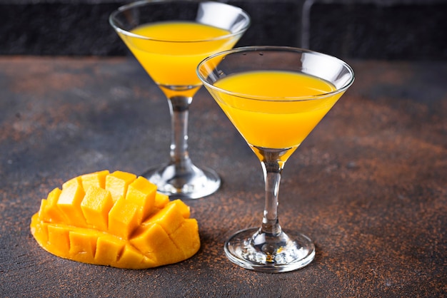 Tropical cocktail with mango on dark background