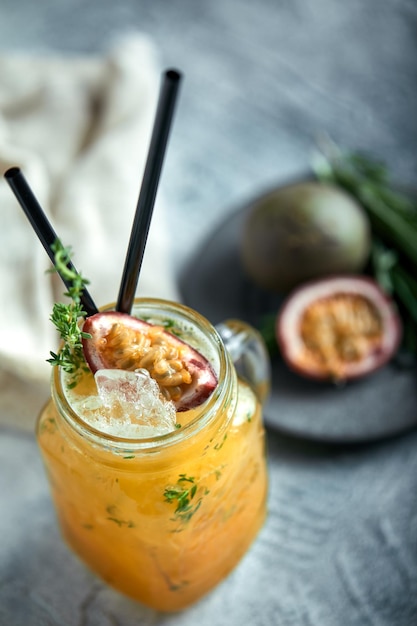 Cocktail tropicale con frutto della passione lime e menta su sfondo grigio area di lavoro cocktail di concetto reale stile alimentare di concetto di cibo copia spazio pubblicità alimentare per riviste e social network