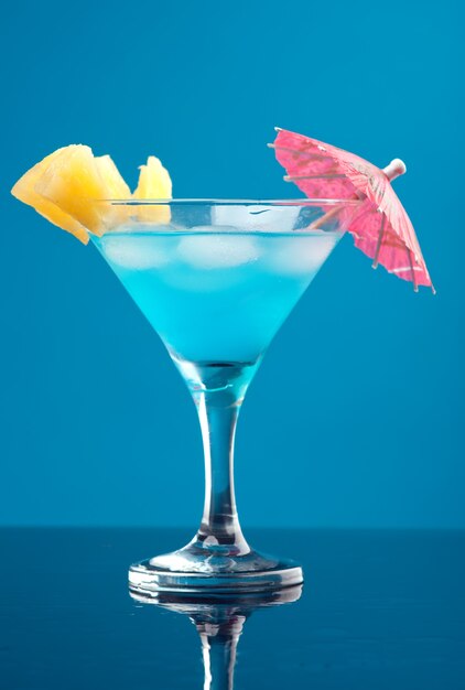 Tropical cold cocktail closeup on blue wall