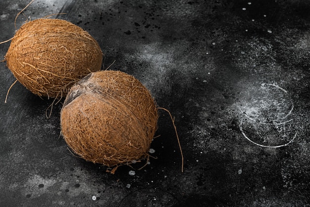 Tropical fruit coconut whole set, on black dark stone table background, top view flat lay, with copy space for text