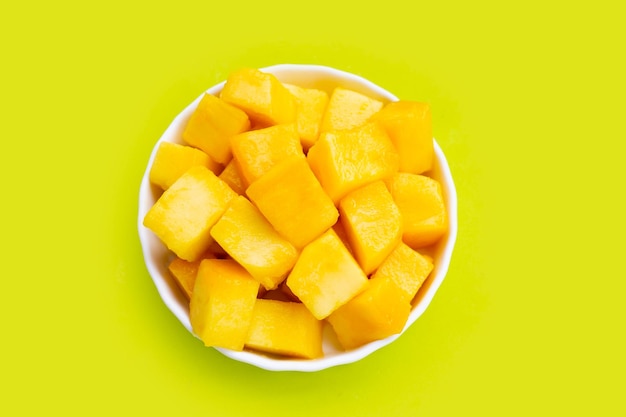 Tropical fruit Mango cube slices on green background