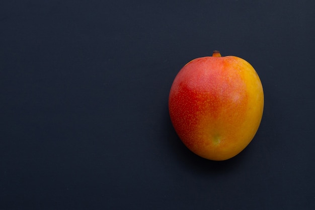 トロピカルフルーツ、暗い壁にマンゴー。