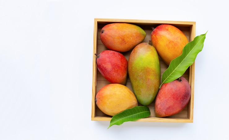 Photo tropical fruit, mango in wooden box on white background.
