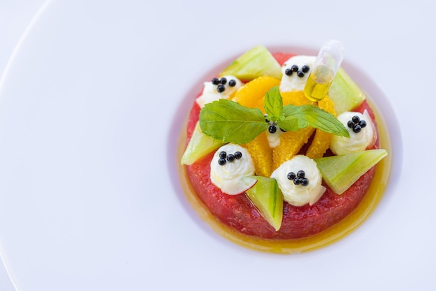 Tropical fruit salad with dragon fruit, watermelon and orange papaya on white elegant background