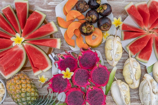 Tropical fruits assortment, close up, top view. Many colorful ripe fruits background. Durian, papaya, watermelon, banana, mangosteen, pineapple and pitahaya or dragon fruit in island Bali, Indonesia