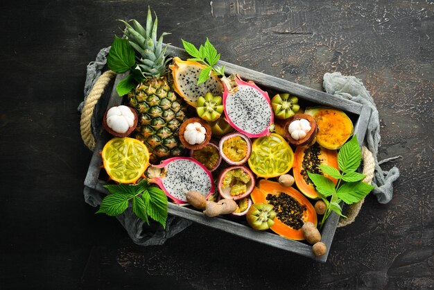 Tropical fruits on a brown background papaya mangosteen cactus fruit pytahaya pineapple Top view Free space for text