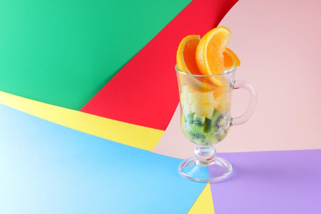 Tropical fruits in glass slices of orange kiwi and pineapple in glass healthy food concept