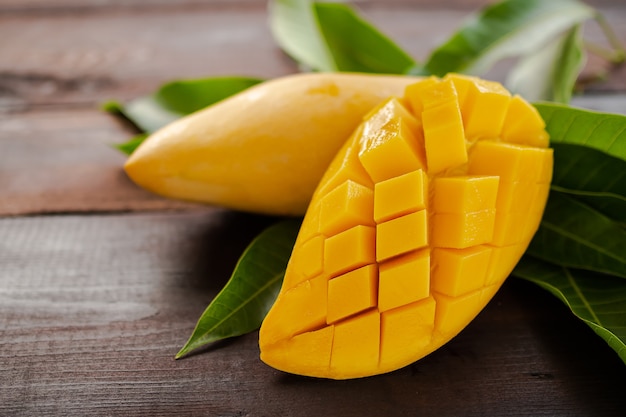 Tropical Fruits mango sliced with leaves mango on wooden.