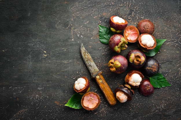 Tropical fruits, Mangosteen on a wooden background. Top view. Free space for text.