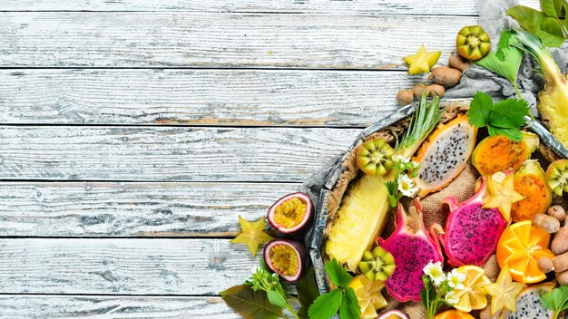 Tropical fruits Maracuya pineapple dragon fruit kiwi and cactus on a white background Top view Free space for text