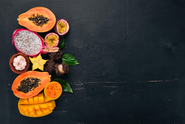 Tropical fruits papaya Dragon Fruit rambutan tamarind cactus fruit avocado granadilla carambola kumquat mango mangosteen passionfruit coconut On a wooden background