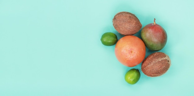 青の背景にトロピカル フルーツ トップ ビュー グレープ フルーツ ココナッツ ライムとマンゴー