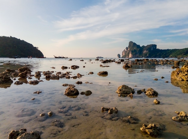 Tropical island beach at low tide landscape. The water level dropped, and see the bottom of the ocean