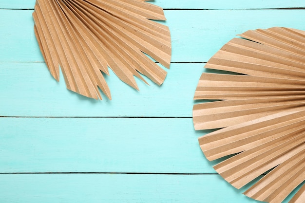 Tropical minimalistic background Dry palm leaves on a blue wooden background Top view