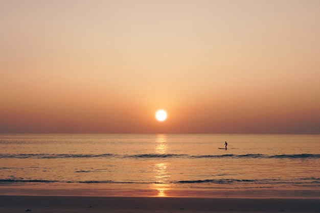 熱帯の自然は太陽の光の背景できれいなビーチの日没の空の時間をきれいにします。