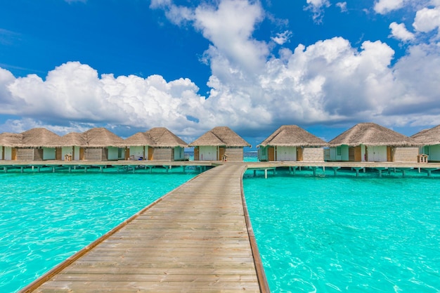 Tropical resort luxury water villa resort with wooden pier Sea lagoon blue sunny sky traveling