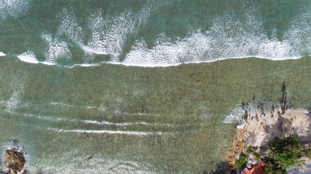Tropical sea with wave crashing on beach aerial view drone shot