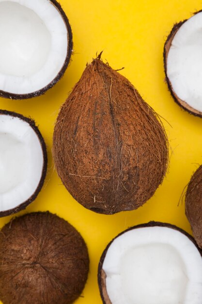 Tropical summer coconut background half and whole coconuts on a yellow background