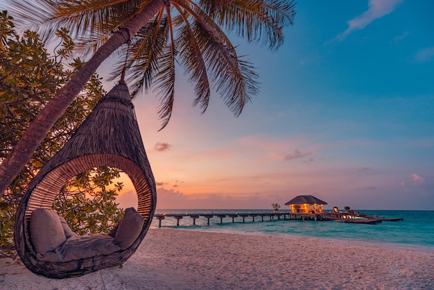 Tropical sunset beach background, summer island landscape with beach swing or hammock sand romance