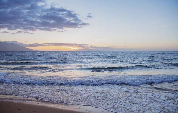 Scena di spiaggia al tramonto tropicale vista mare dalla spiaggia estiva con cielo paesaggio costiero