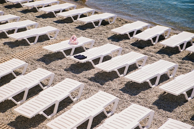 Sfondo vacanza tropicale sedie a sdraio bianche per attività all'aperto sulla spiaggia vista dall'alto luce solare intensa