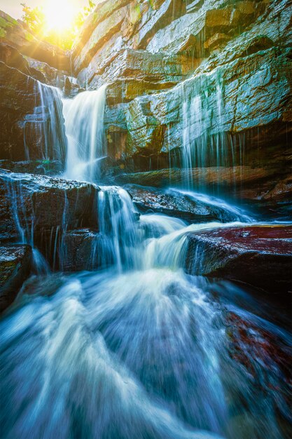 Tropical waterfall with sun rays