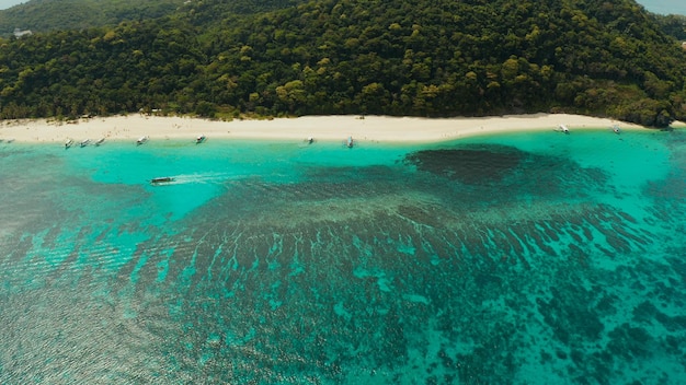 フィリピンのボラカイ島の上から見た青いラグーンとサンゴ礁の近くの熱帯の白い砂浜