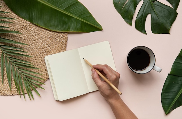 Tropical workspace concept Notepad and tropical palm leaves Mockup presentation workplace