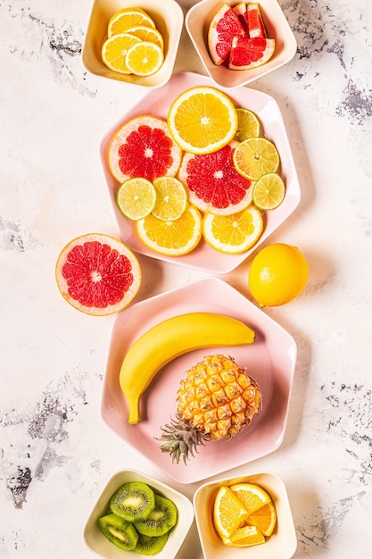 Tropisch fruit geheel en plakjes op platen, bovenaanzicht.