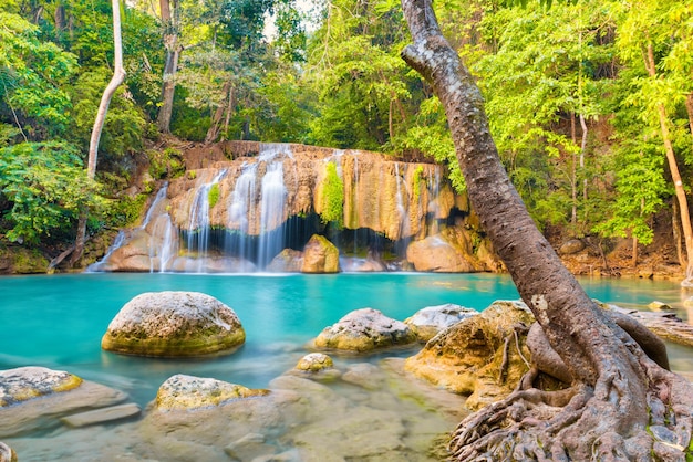 Tropisch landschap met prachtige waterval smaragdgroene meerrotsen en grote boomwortels in wild junglebos Erawan National park Kanchanaburi Thailand