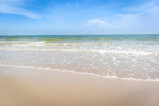 Tropisch strand met groene oceaan en kleine golf.