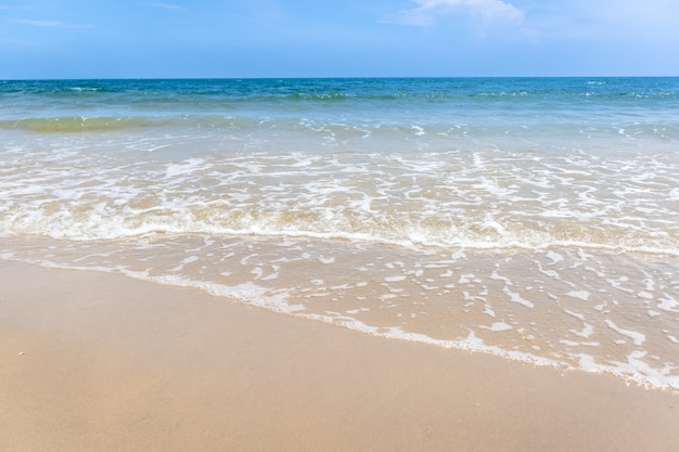 Tropisch strand met groene oceaan en kleine golf.