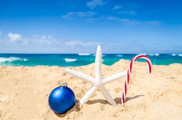 Tropisch strand met kerstbal, snoepje en zeester