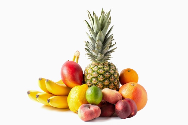 Tropisch vruchten assortiment dat op witte achtergrond wordt geïsoleerd. Ananas, bananen, mango, ime, citroen, perziken.