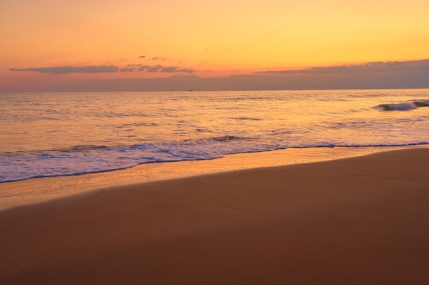 Tropisch zandstrand bij zonsondergang