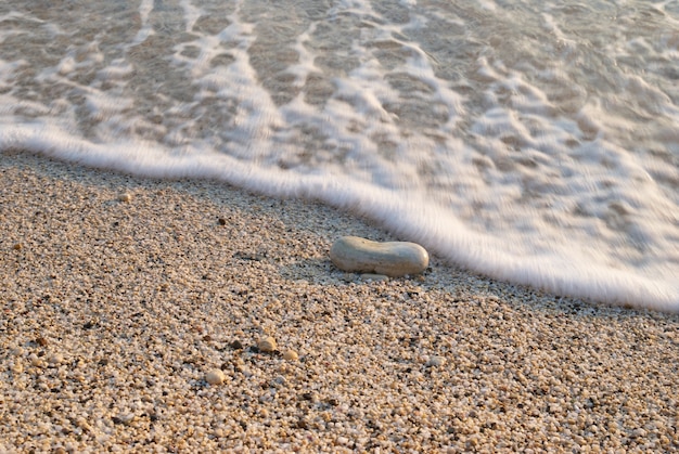 Tropisch zandstrand met golven van de zee en stenen.