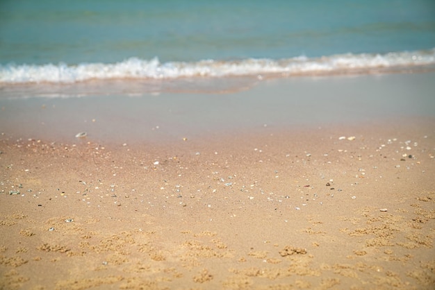 Tropisch zandstrand met wazige golven op de achtergrond