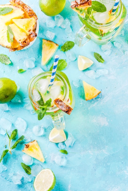 Tropische drank ananasmojito of limonade met verse limoen en mint lichtblauwe achtergrond